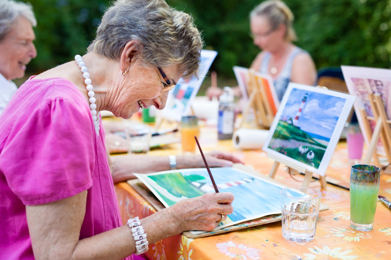 Senior woman smiling while drawing with the group. Cindy Bakewell Travel Painting holiday